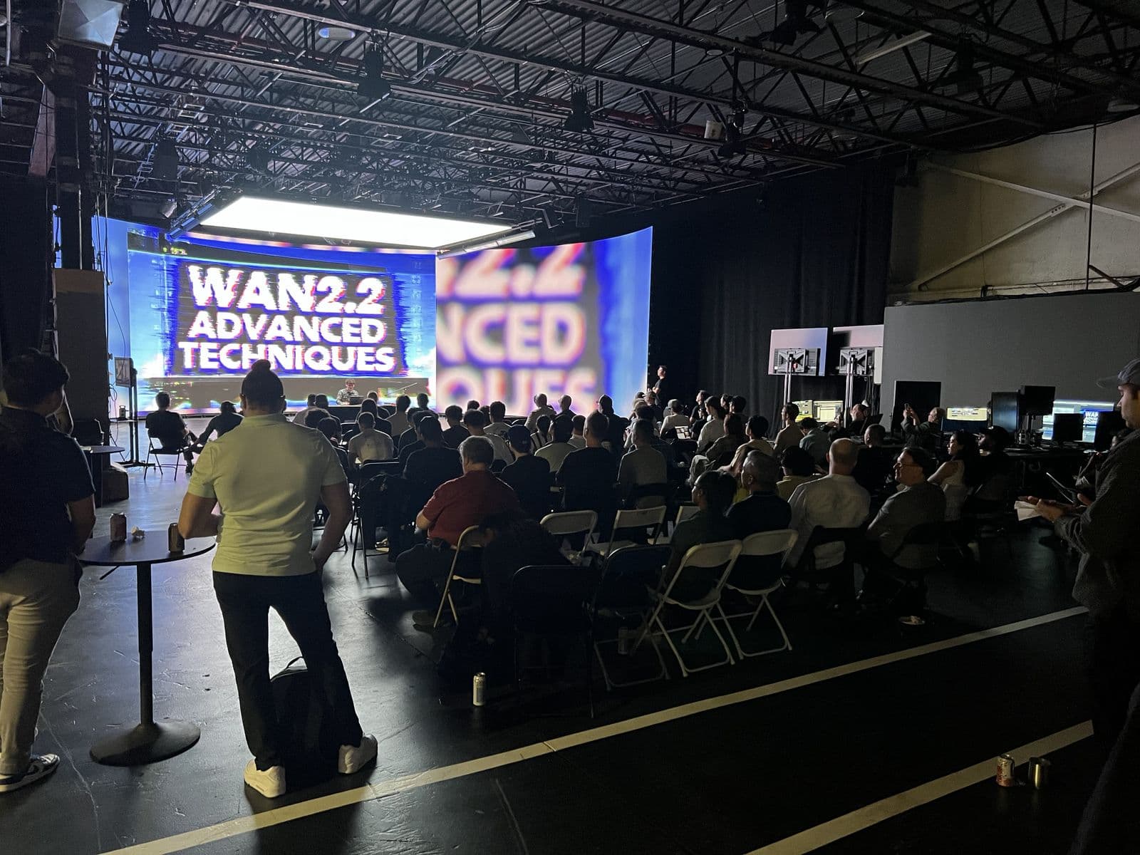 A workflow breakdown on screen in front of a seated crowd